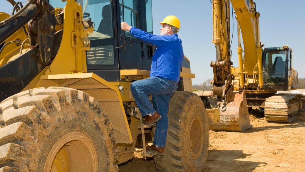 Pessoa trabalhando como operador de máquinas pesadas em um canteiro de obras. 